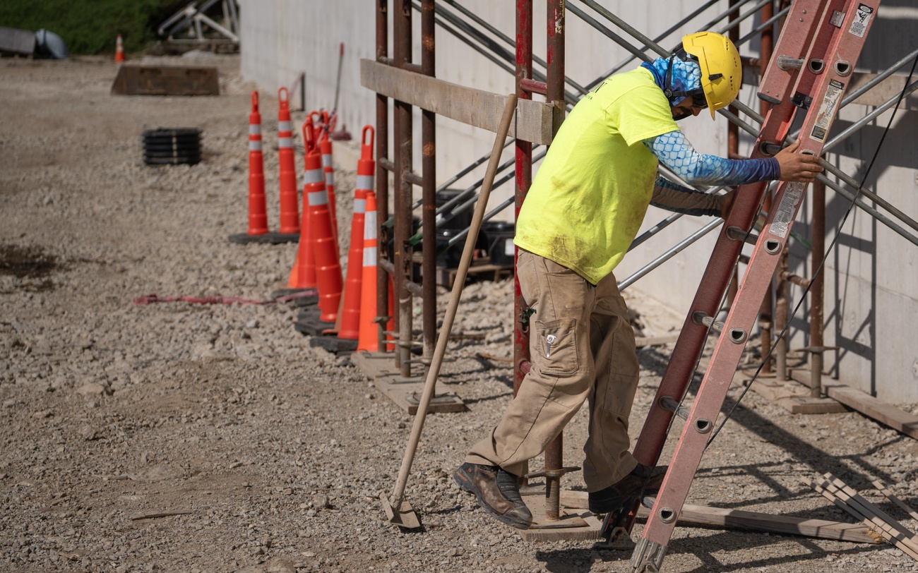 Construction Worker Walking Down from Ladder